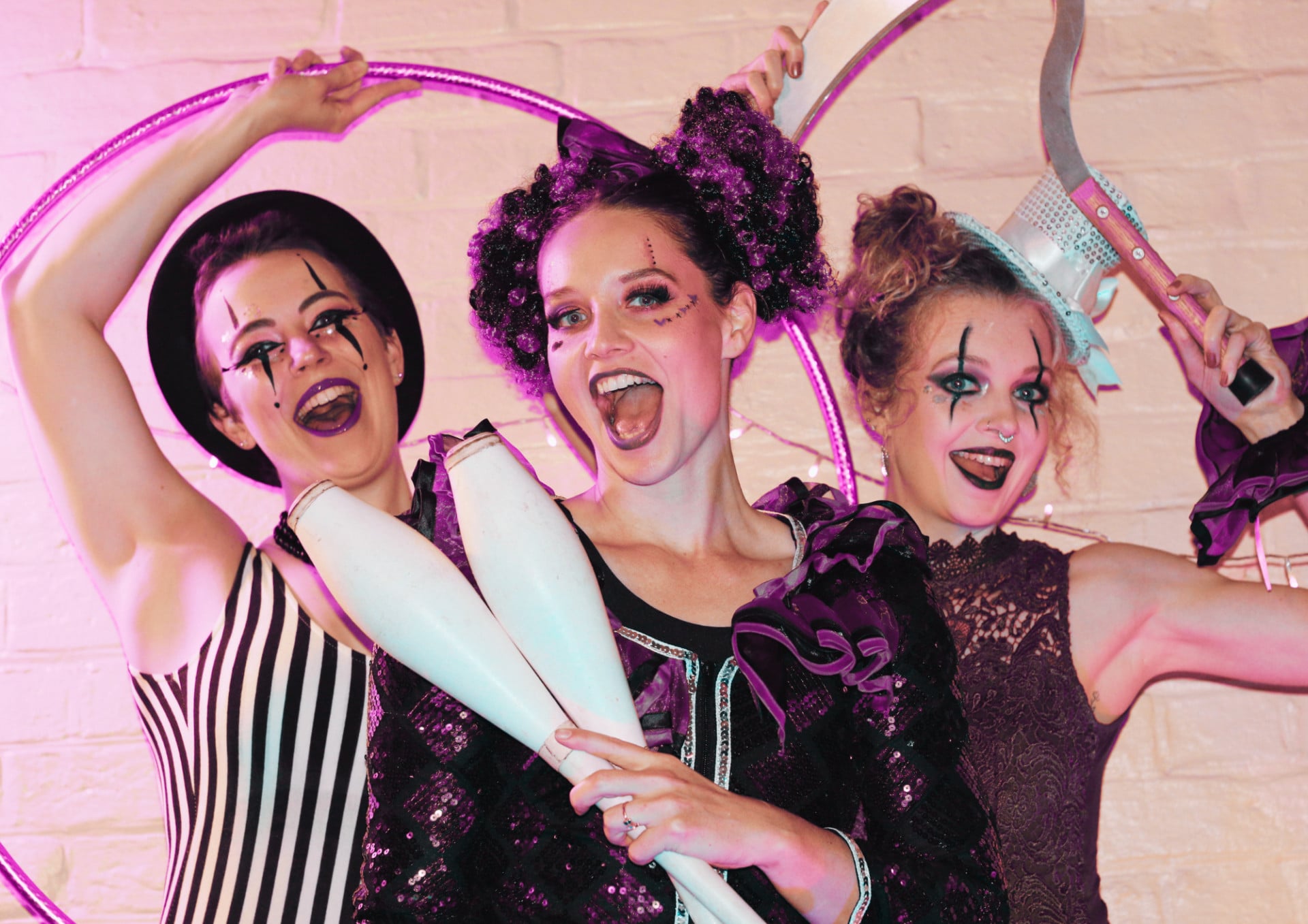 Three Sparkle Society Creepy Carnival performers in purple and black costumes with clown make-up